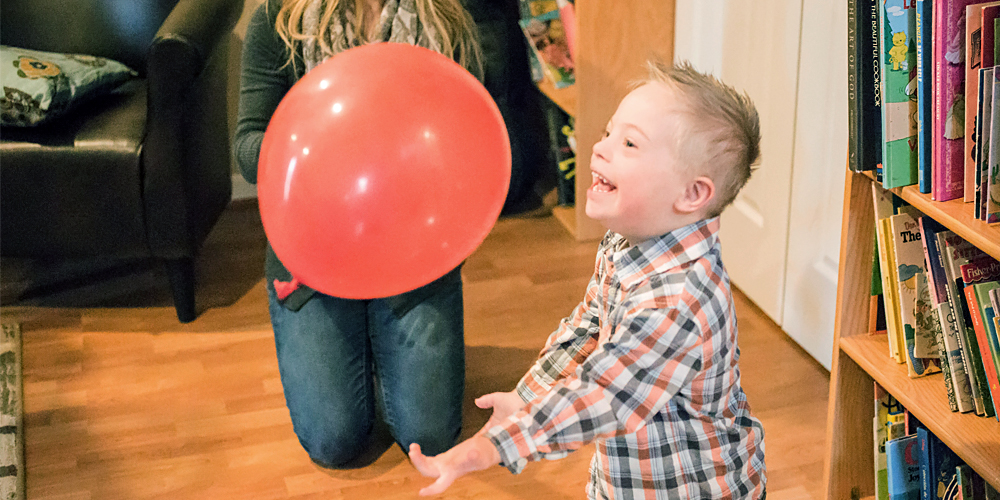 photo of a child playing with a red balloon