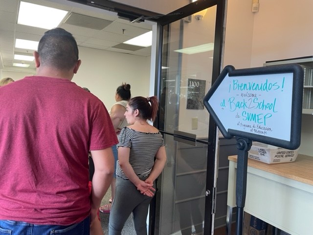parents enter a meeting with a welcome sign by the door